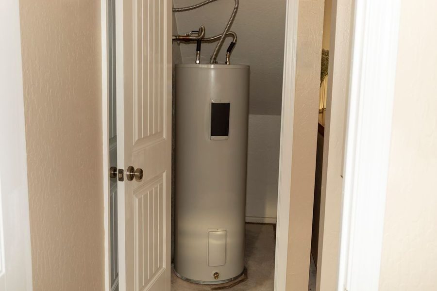 Standard tank water heater in a utility closet in a home